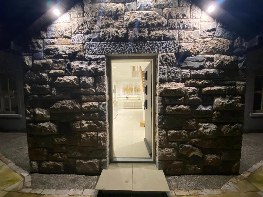 a door in a stone wall with lights at The Last Resort With Hot Tub And Car Service in Warrenpoint