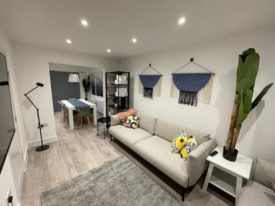 un salon avec un canapé et une table dans l'établissement New 4 bedrm house! Parking. 10min to City / Etihad, à Manchester