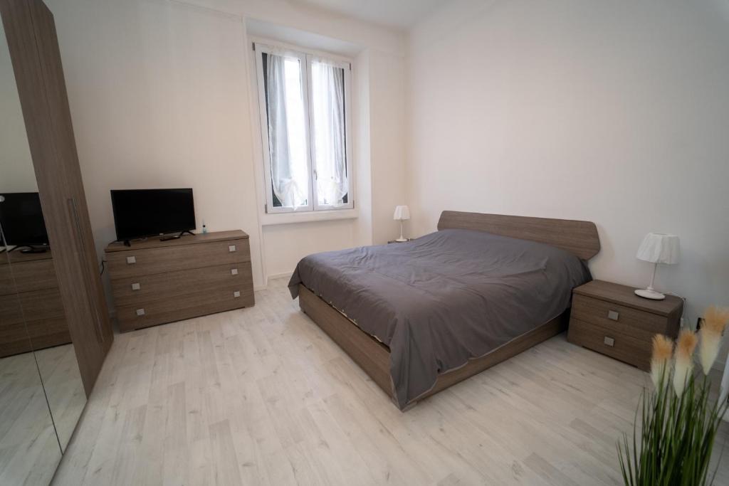 um quarto com uma cama, uma televisão e uma cómoda em AG apartment em Cormano
