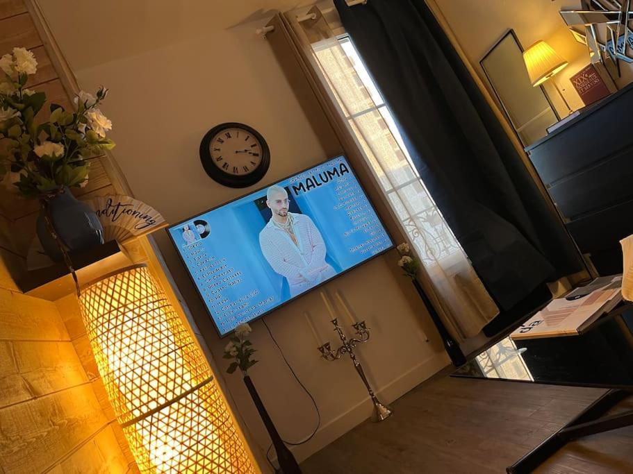 Cette chambre dispose d'une affiche murale et d'une horloge. dans l'établissement Paris flat, à Malakoff