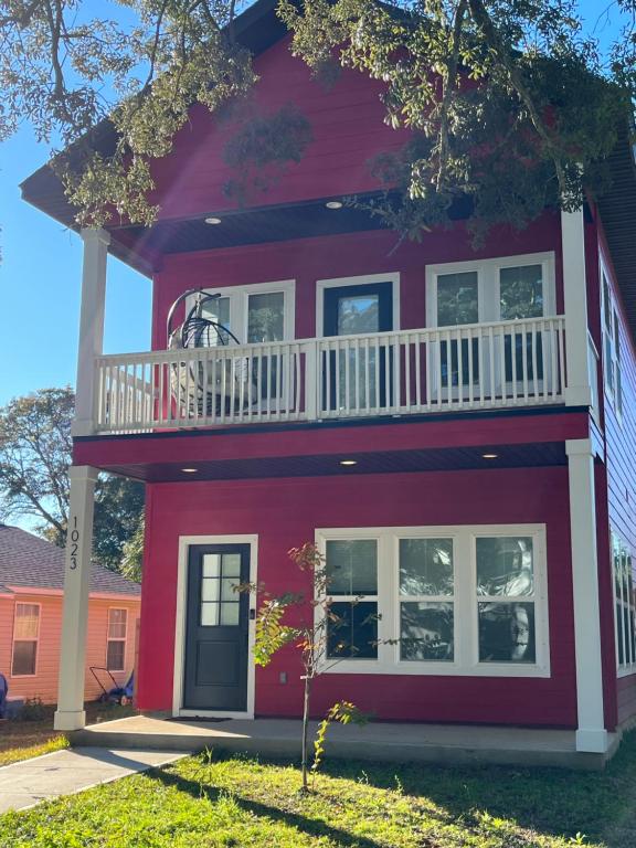 una casa roja con balcón en la parte superior. en The Clifford House en Pensacola