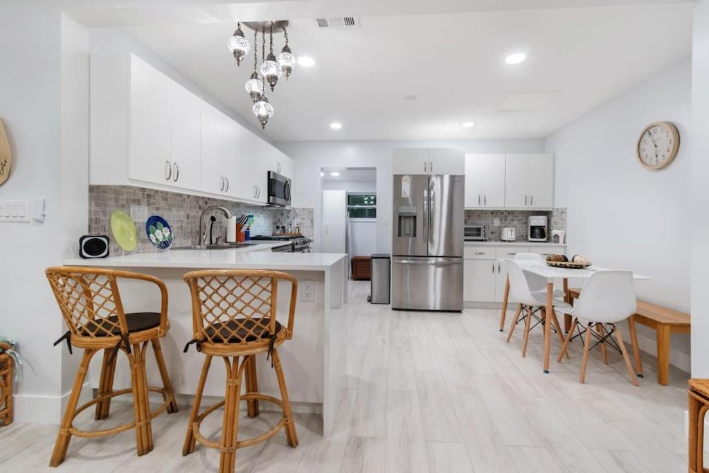 a kitchen with white cabinets and a table and chairs at Summer By The Sea 2 in Pompano Beach