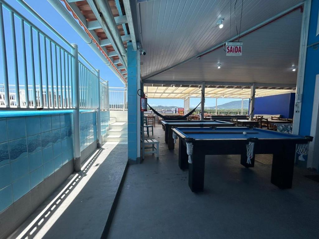 a row of ping pong tables sitting inside of a building at Ilha azul hospedagem in Florianópolis