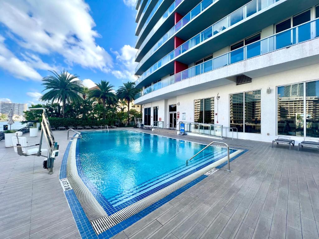 a large swimming pool in front of a building at MVR Apartments at Beachwalk Resort in Hallandale Beach