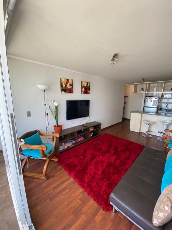 sala de estar con sofá y alfombra roja en Departamento en Valparaíso, en Valparaíso