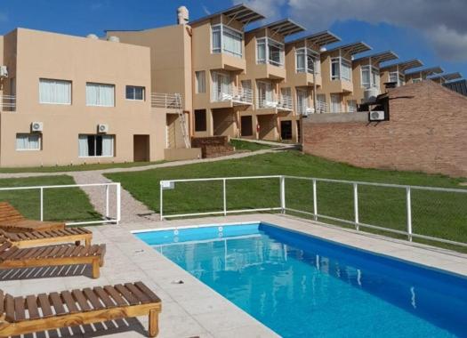 a swimming pool in front of an apartment complex at Departamento Naposta y Tres Picos in Sierra de la Ventana
