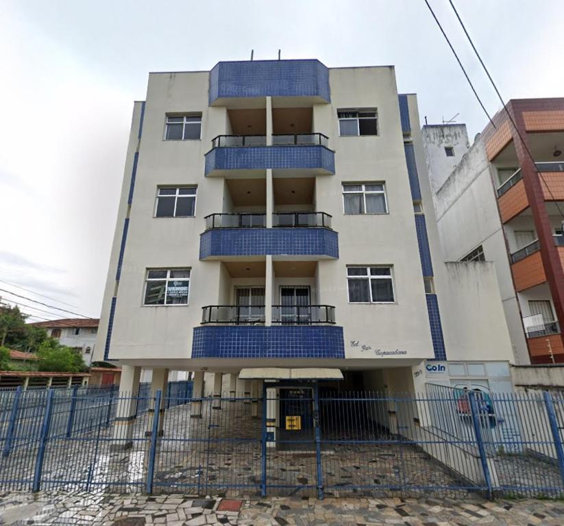 ein Gebäude mit blauen Balkonen auf der Seite in der Unterkunft Residencial Copacabana in Guarapari