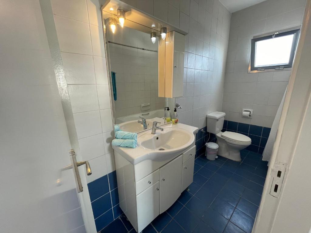 a bathroom with a sink and a toilet at Pissouri Beach Apartments in Pissouri