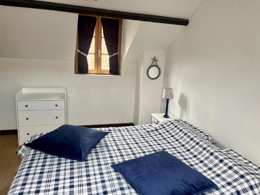 une chambre avec un lit avec des oreillers bleus et une fenêtre dans l'établissement Maison de centre-village 