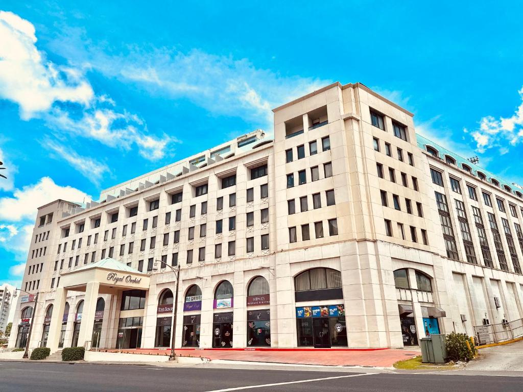 a large white building on the corner of a street at Royal Orchid Hotel Guam in Tumon