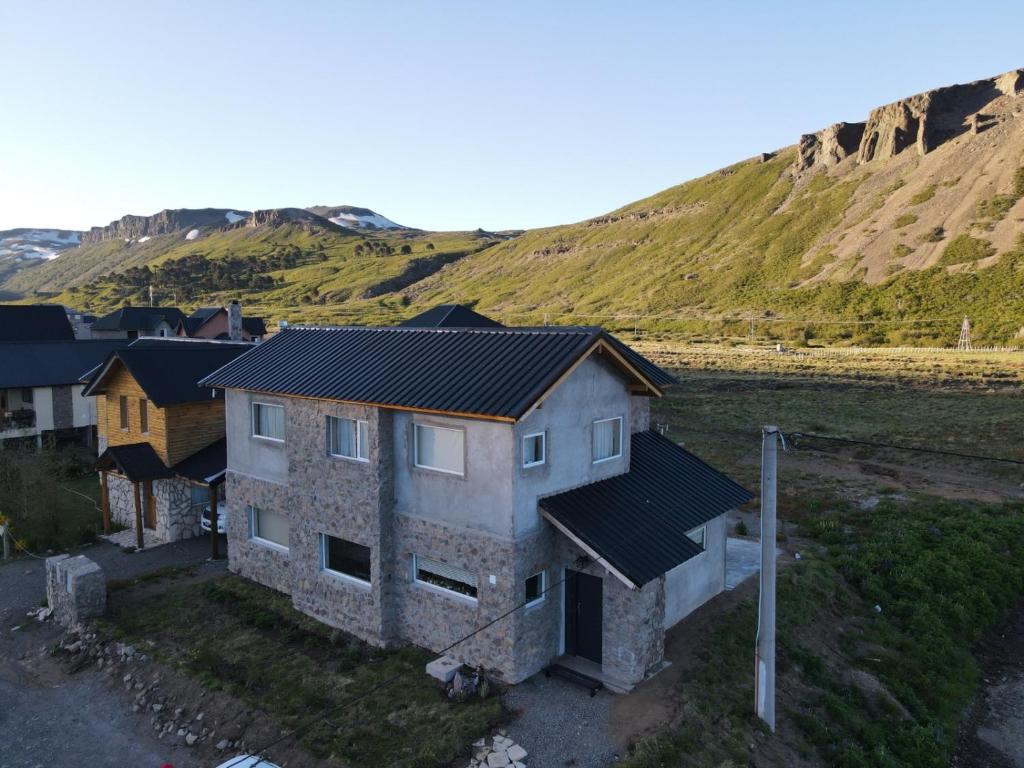 une vue aérienne sur une maison avec une montagne en arrière-plan dans l'établissement CUNCUMEN Caviahue, à Caviahue