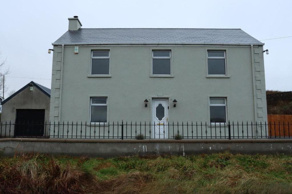 a white house with a fence in front of it at Biddy Rua's Place in Killybegs