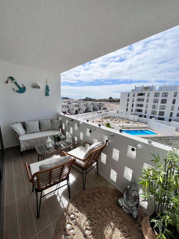 a balcony with a couch and chairs and a pool at Departamento full equipado en Bahía Inglesa in Bahia Inglesa