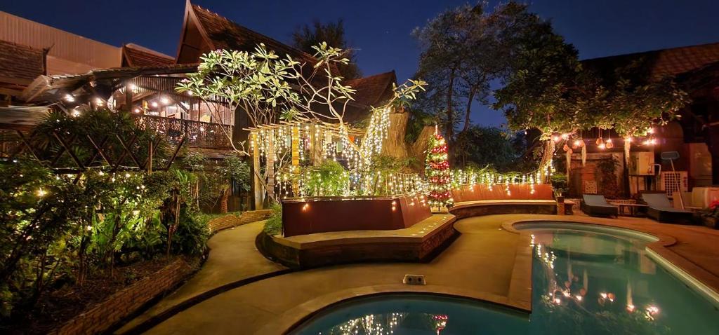 una casa con piscina con luces de Navidad en Club One Seven Gaymen Chiang Mai, en Chiang Mai