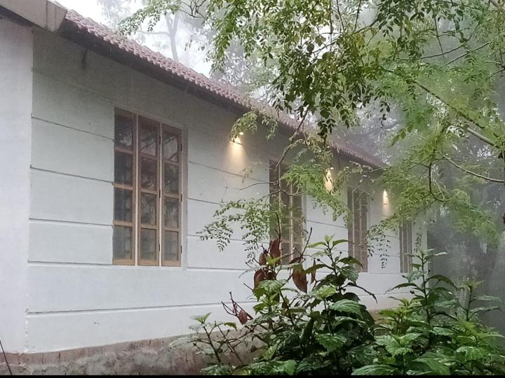 une maison blanche avec des fenêtres latérales dans l'établissement River View Guest Rooms, à Vythiri