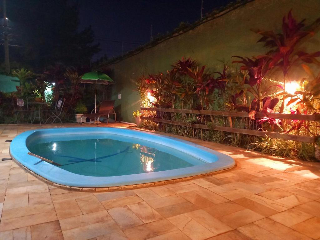 a large blue swimming pool on a patio at night at Casa Sobrado com piscina Santa Felicidade 6 pessoa in Curitiba