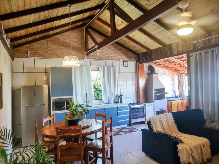 - une cuisine et une salle à manger avec une table et un canapé dans l'établissement Casa Pôr do Sol com churrasqueira ar condicionado, à Florianópolis