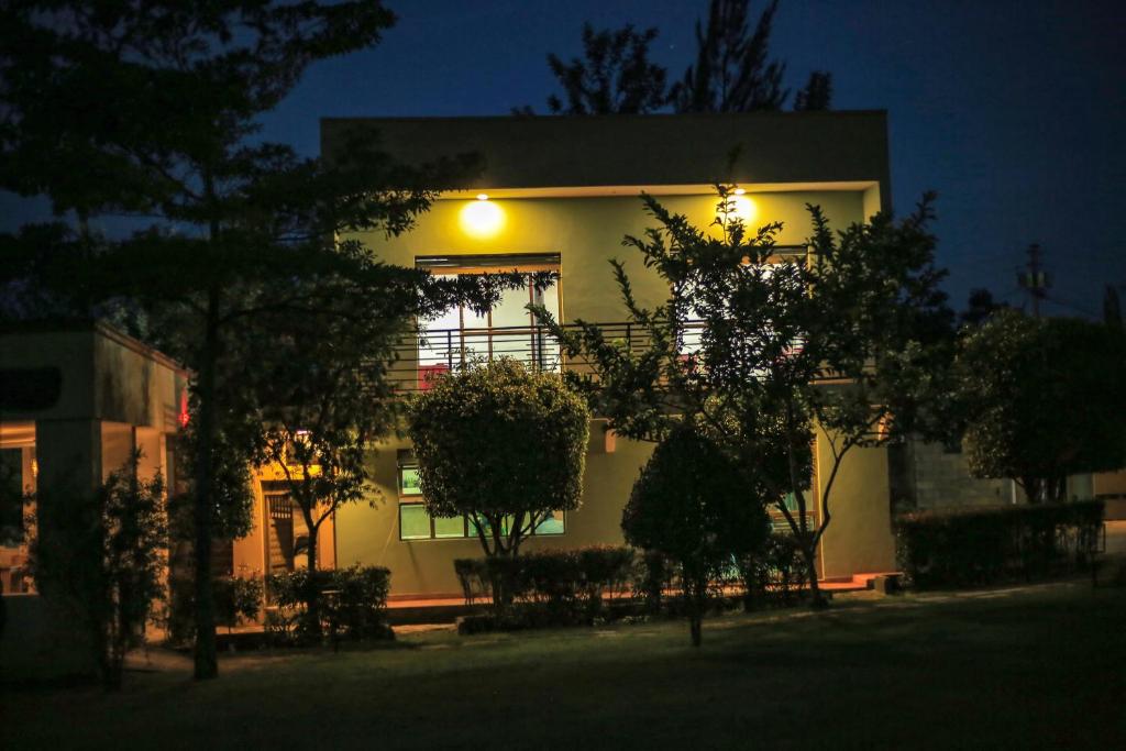 un edificio con una luz a un lado por la noche en Triple Tee Gardens & Accomodation en Wakiso