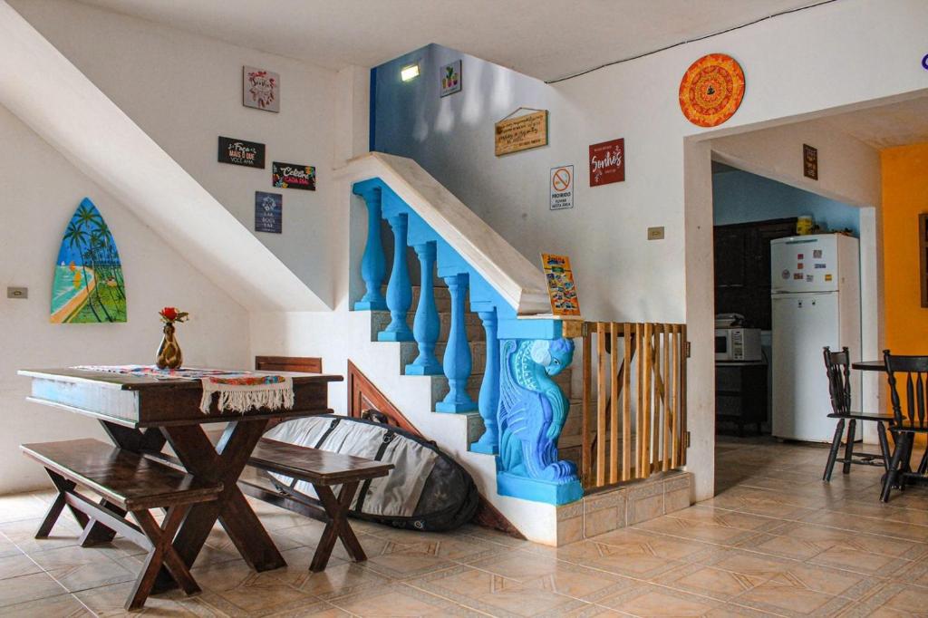 a staircase in a living room with a table and a kitchen at Estação do Mar Hostel in Porto De Galinhas