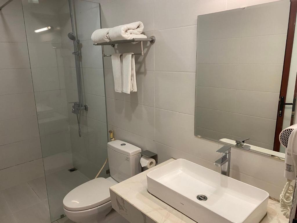 ein Badezimmer mit einem WC, einem Waschbecken und einem Spiegel in der Unterkunft Thanh Lam Hotel - 23A BT1, KDT Bắc Linh Đàm - by Bay Luxury in Hanoi