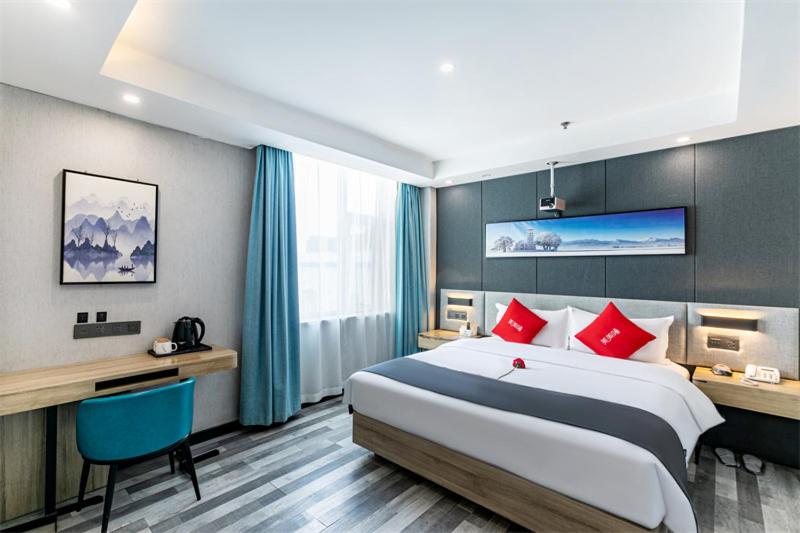 a hotel room with a large bed with red pillows at Thank Inn Plus Hotel shanxi taiyuan yingze district liuxiang pedestrian street in Taiyuan