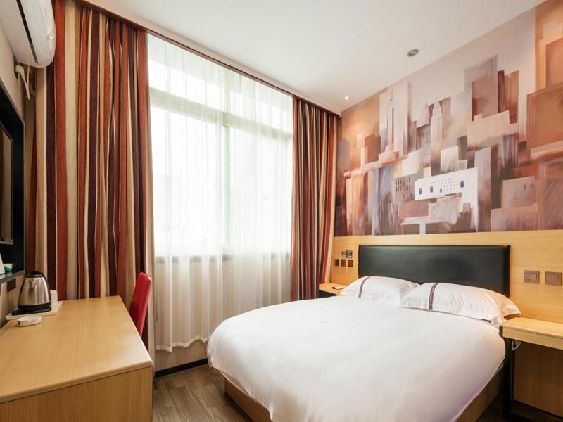una camera da letto con un grande letto bianco e una finestra di Thank Inn Chain Hotel jiangxi nanchang west lake district August 1st plaza a Nanchang