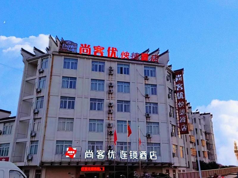 ein Gebäude mit chinesischen Schildern oben drauf in der Unterkunft Thank Inn Plus Hotel Jiangsu Taizhou Dainan Tuanjie in Shiyan