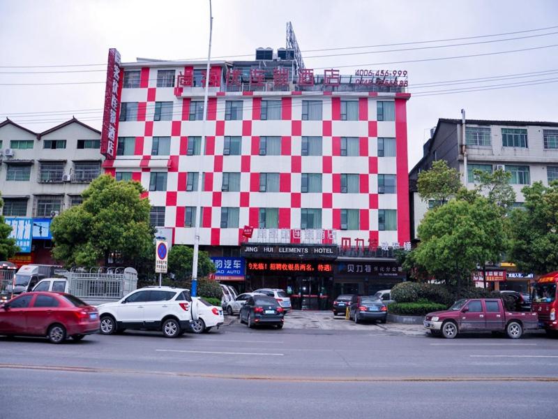ein rotweißes Gebäude mit Autos auf einem Parkplatz in der Unterkunft Thank Inn Chain Hotel Hunan Huaihua Hecheng District South High Speed Rail Station in Huaihua