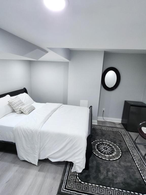 ブランプトンにあるSUITE A 2 Bedroom Apartmentの大きな白いベッドと鏡のある寝室