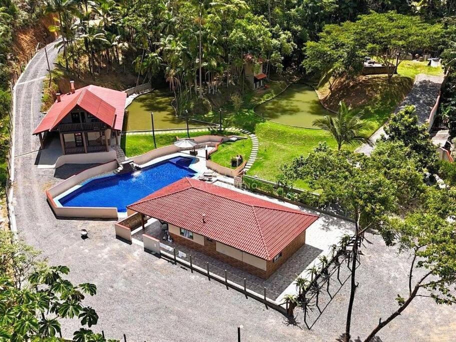 Cette chambre offre une vue sur une maison dotée d'une piscine. dans l'établissement Sítio Ribeirão Bonito, à Pinheiral