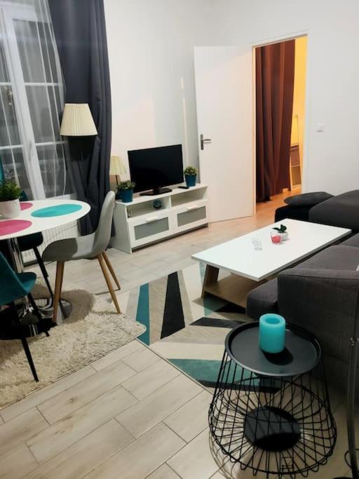 un salon avec un canapé et une table dans l'établissement Appartement à 10 min d'Orly/ 15min de Paris, à Juvisy-sur-Orge
