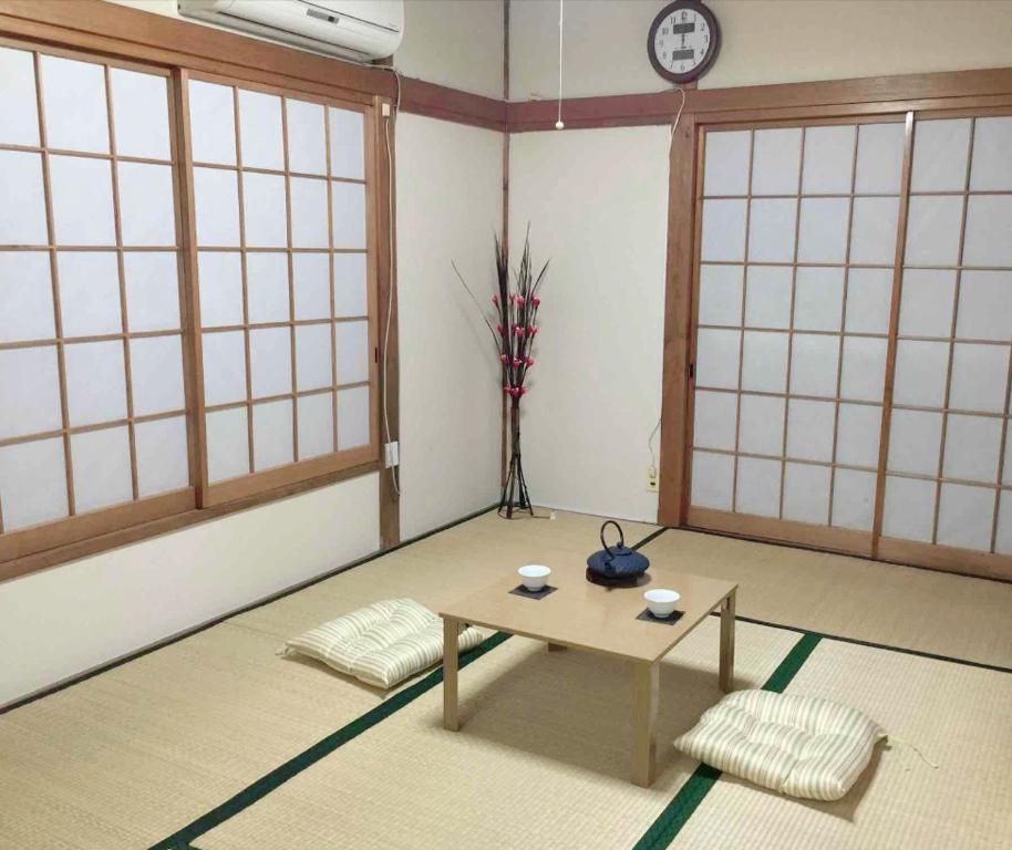 een kamer met een tafel in een kamer met ramen bij Tokyo Kamakura House in Tokyo