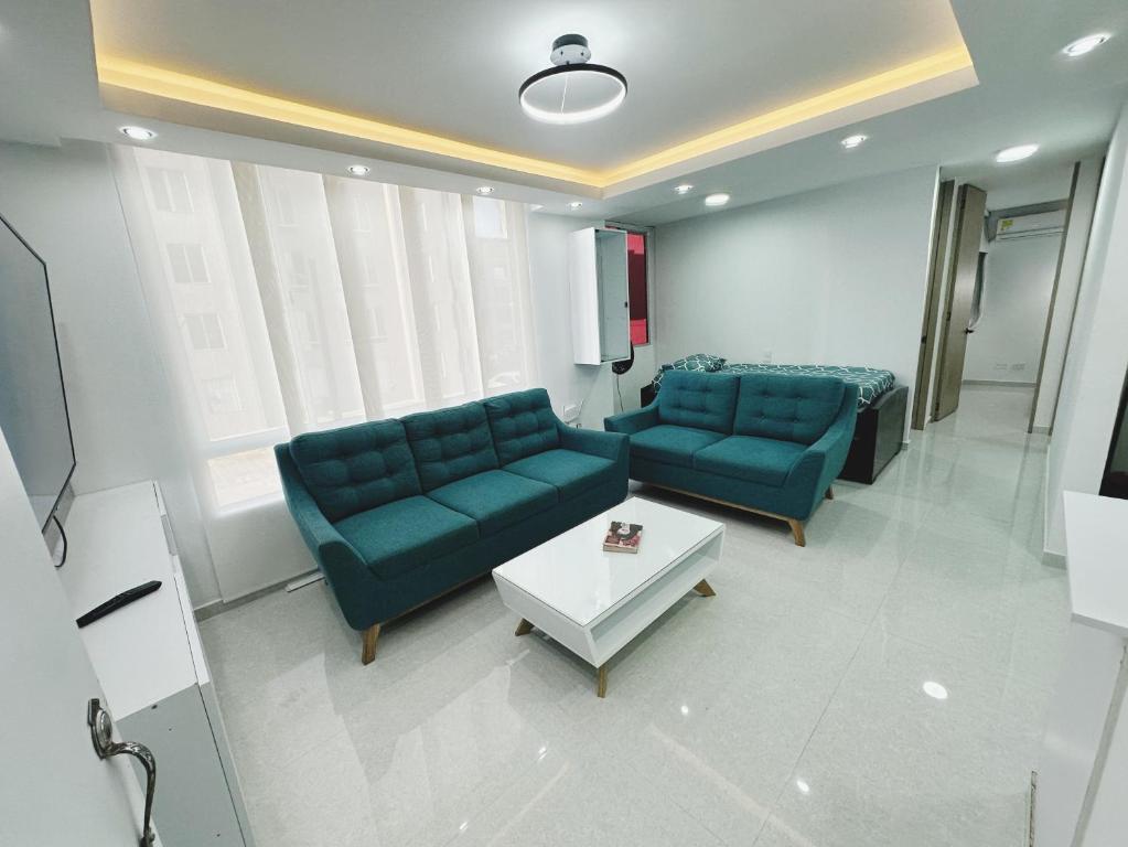 una sala de estar con 2 sofás azules y una mesa. en Apt nuevo 15min CC BuenavistValmundo TV50 Netflix, en Barranquilla