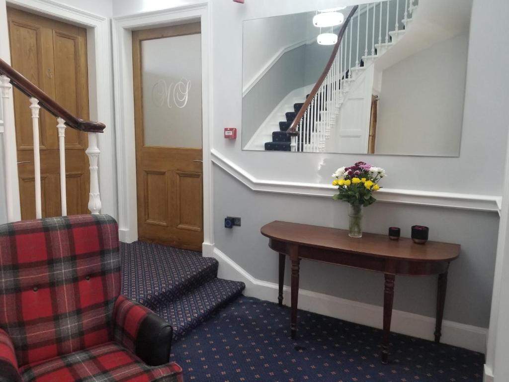 un escalier avec un vase de fleurs sur une table dans l'établissement Mayfield Suites, à Édimbourg