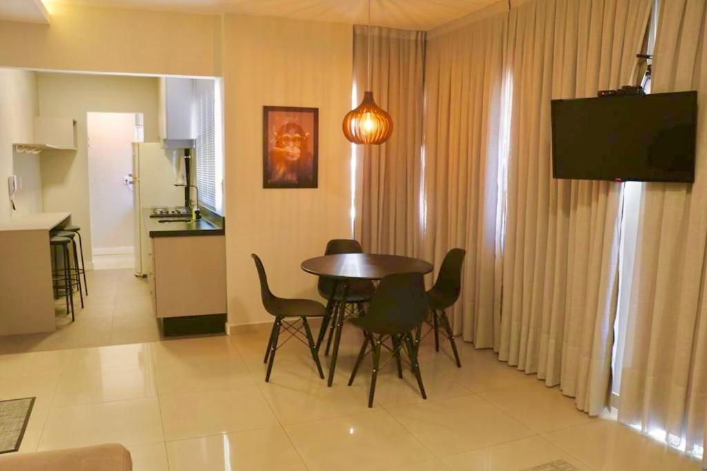 uma sala de estar com mesa e cadeiras e uma cozinha em Lindo apto 2 quartos quadra mar em Balneário Camboriú