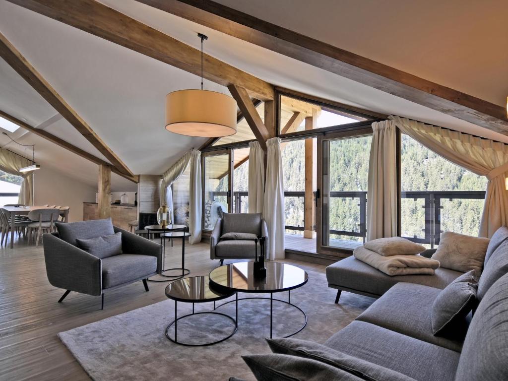 a living room with furniture and large windows at Appartement rénové avec ski aux pieds, 4 chambres et prestations incluses à Courchevel - FR-1-613A-29 in Courchevel