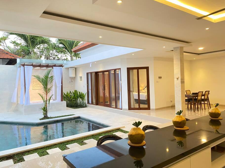 a villa with a swimming pool and a house at Villa Akmali Umalas 2BR with Private Pool & Jacuzzi in Canggu
