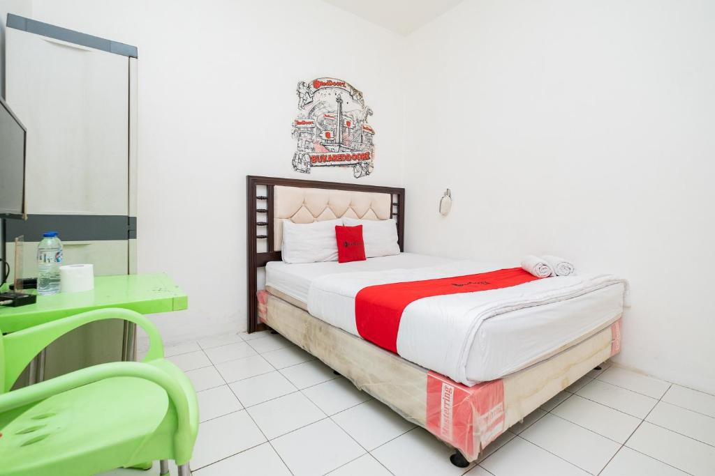 Schlafzimmer mit einem Bett und einem Spiegel in der Unterkunft RedDoorz near STAN in Tangerang