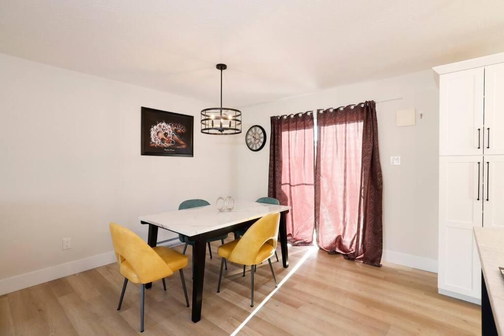 a dining room with a table and yellow chairs at Luxury Home In Moncton in Moncton