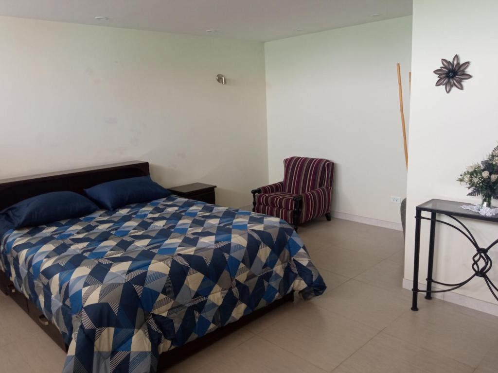 um quarto com uma cama, uma cadeira e uma mesa em Casa villa Eru em Pisco