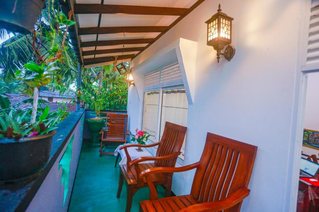 two chairs and a table on a porch with plants at Villa Kavee in Galle