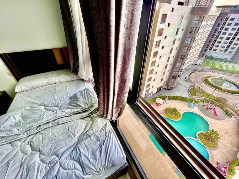 a bedroom with a bed and a window with a view at UNIQue 2BRs LOCation l DOWNTown NEWCairo/City view in Cairo
