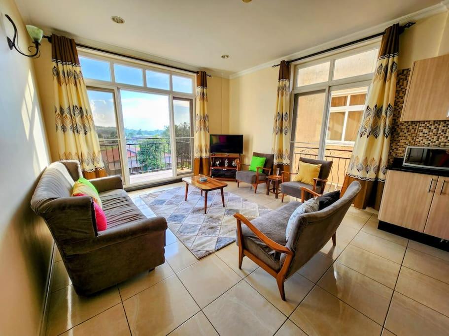 - un salon avec deux chaises et une grande fenêtre dans l'établissement Apartment in a Gated Community, à Arusha