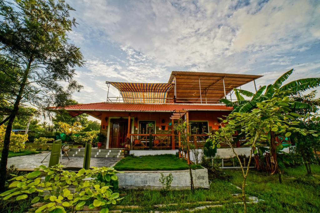 a house with a roof in a garden at 6Tamarind in Gholvad
