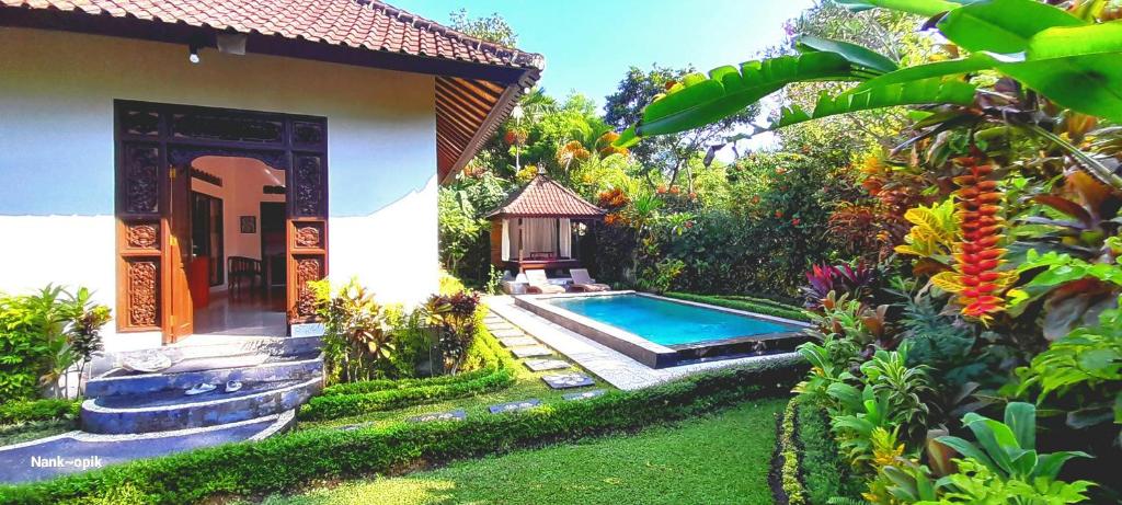 un jardin avec une piscine à côté d'une maison dans l'établissement Sari Kembang villa ubud, à Ubud