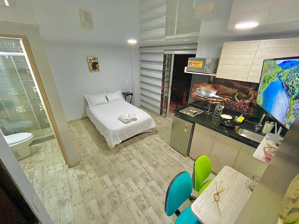 Habitación con cama y cocina con fregadero en Las Aguas Studios, en Bogotá