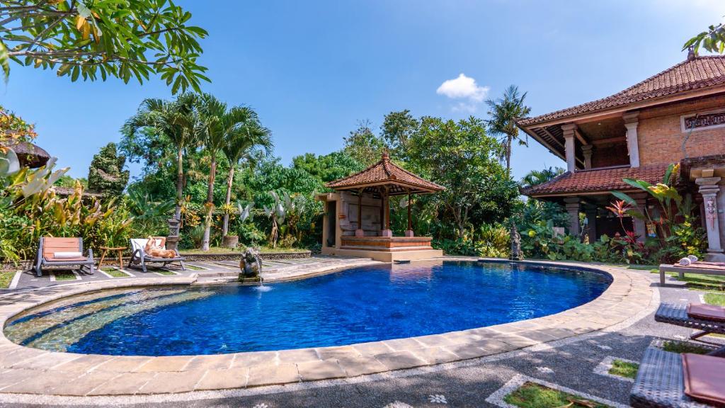 a pool in a backyard with a gazebo at Garden View Ubud in Ubud