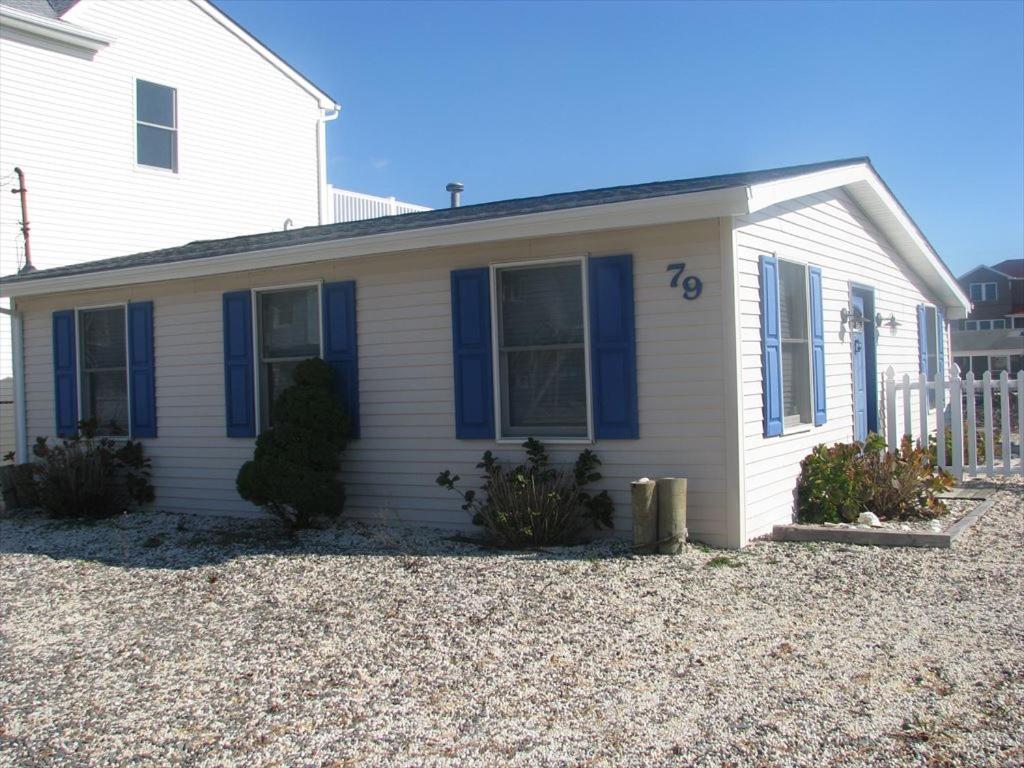 Maison blanche avec fenêtres bleues et volets bleus dans l'établissement Super Cute!! Waterfront Lagoon In Beach Haven West!, à Manahawkin