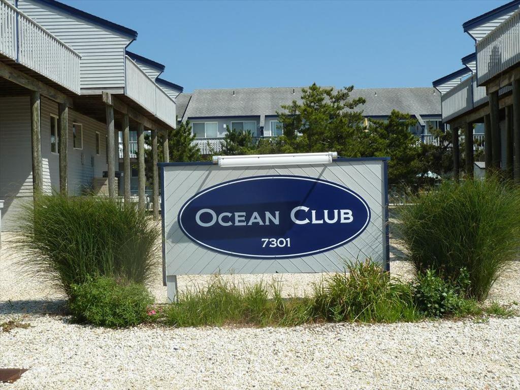 un panneau pour un club de l'océan en face des maisons dans l'établissement Ocean Club Condo, Brant Beach, One Block To The Ocean!, à Brant Beach