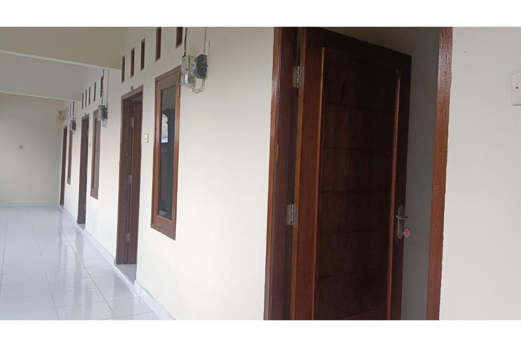 um corredor vazio com uma porta num edifício em SPOT ON 93524 Bagas Homestay em Lembuak